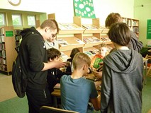 Uczestnicy wybierają książki i czytają je w ciszy