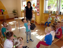 Chłopczyk sprawdza jak cięzki jest kufer z książkami Tuwima