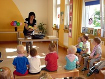 Bibliotekarka wyjmuje z kufra książki Juliana Tuwima i krótko o nich opowiada