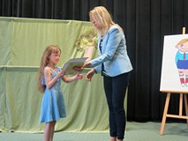 Z-ca dyrektora KBP, Beata Sawa-Jovanoska wręcza nagrodę książkową dziewczynce