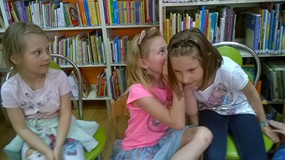 dzieci siedzą w kole i bawią się w 