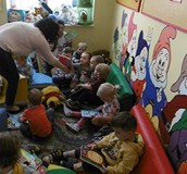 Bibliotekarka prezentuje dzieciom książki.