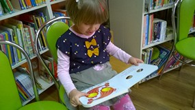 Dziewczynka siedzi z pasjonującą lekturą