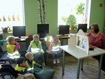 Przedszkolaki słuchające bibliotekarki