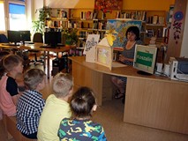 Dzieci siedzą na ławeczkach i słuchają LEGENDY O PIĘKNEJ LINIE (w teatrzyku Kamishibai)