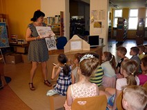 Bibliotekarka prezentuje jedne z ciekawszych ilustracji - wykonanych przez dzieci w bibliotece - do 