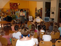 Bibliotekarka prezentuje jedne z ciekawszych ilustracji - wykonanych przez dzieci w bibliotece - do 