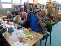 Pani prezentuje swoje robótki ręczne