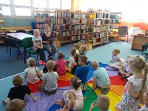 Bibliotekarka i mała czytelniczka czyta razem z dziećmi łamańce językowe