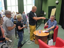 Marcin Meller rozdaje autografy po spotkaniu autorskim w Koszalińskiej Bibliotece Publicznej