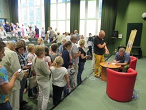 Marcin Meller rozdaje autografy po spotkaniu autorskim w Koszalińskiej Bibliotece Publicznej