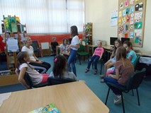 Dzieci siedzą w kole na krzesłach podczas wspólnej zabawy