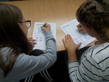 Dwie dziewczynki rozwiązują krzyżówkę i wykreślankę w języku angielskim