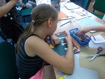 Dziewczynka wykonuje laurkę dla swojego taty