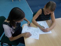 Dziewczynki podczas rozwiązywania krzyżówki i wykreślanki