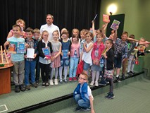 Grzegorz Kasdepke w Koszalińskiej Bibliotece Publicznej wraz z dziećmi pozuje do zdjęcia