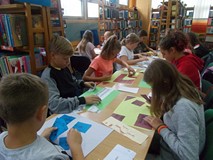 dzieci przy stołach wykonują prace plastyczne