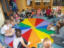 Dzieci siedzą na chuście animacyjnej