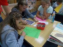 Trzy dziewczynki przy siedzą przy stole