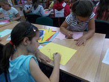 Dwie dziewczynki siedzą przy stole i rysują