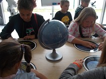 Dzieci szukają ważnych informacji na obrotowej mapie nieba