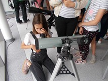 Dziewczynka patrzy przez lornetkę