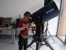 Chłopiec obserwuje świat przez teleskop