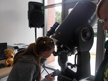 Dziewczynka obserwuje świat przez teleskop