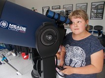 Dziewczynka obserwuje świat przez teleskop