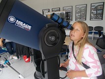 Dziewczynka obserwuje świat przez teleskop