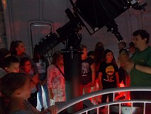 Dzieci i bibliotekarka w kopule z teleskopem głównym