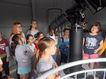 Bibliotekarka z dziećmi w kopule z teleskopem głównym