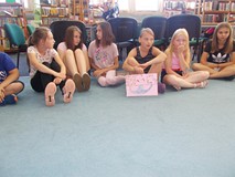 Dziewczynka pokazuje swoją pracę plastyczną