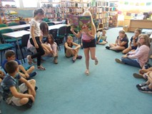 Dziewczynka czyta wiersz stojąc na jednej nodze