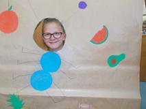 Dziewczynka pozuje do zdjęcia z makietą