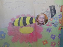 Dziewczynka pozuje do zdjęcia z makietą