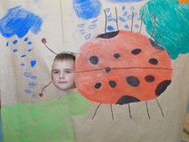 Chłopiec pozuje do zdjęcia z makietą