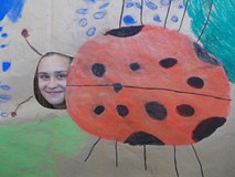 Dziewczynka pozuje do zdjęcia z makietą