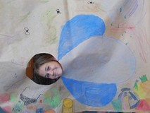 Dziewczynka pozuje do zdjęcia z makietą