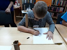 Chłopiec rysuje portret camerą lucida.
