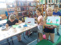 Dwie dziewczynki pozują ze swoimi pracami