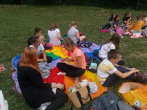 Dzieci siedzą na chuście i piknikują