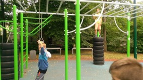 Chłopcy wspinają się na placu zabaw