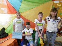 Dzieci prezentują pomalowane przez siebie koszulki.