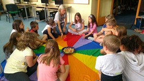 Bibliotekarka gra z dziećmi rzucając kostką