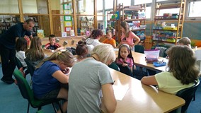 Bibliotekarka wraz z dziećmi wykonuje pracę plastyczną