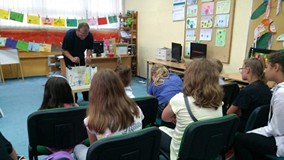 Dzieci siedzą na widowni i oglądają pracę aktora