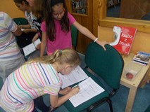 Dwie dziewczynki podczas podpisywania kartek