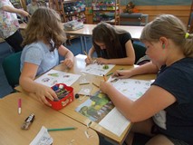 Trzy dziewczynki wykonują prace plastyczną