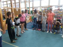 Dzieci stoją w kole i przekładają hula hop